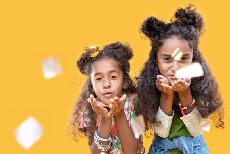Afro Amerikaanse meisjes die van Nice foliestukken blazen bij u royalty-vrije stock foto Afro Amerikaanse meisjes die van Nice foliestukken blazen bij u royalty-vrije stock foto