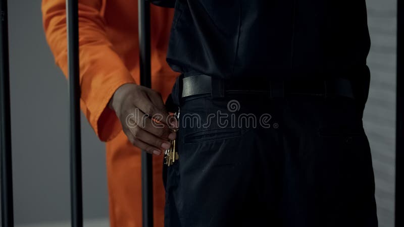 Afro-amerikanischer Gefangener, der Schlüssel aus dem Sicherheitsdienst gestohlen hat, bereitet Flucht vor lizenzfreie stockbilder Afro-amerikanischer Gefangener, der Schlüssel aus dem Sicherheitsdienst gestohlen hat, bereitet Flucht vor lizenzfreie stockbilder