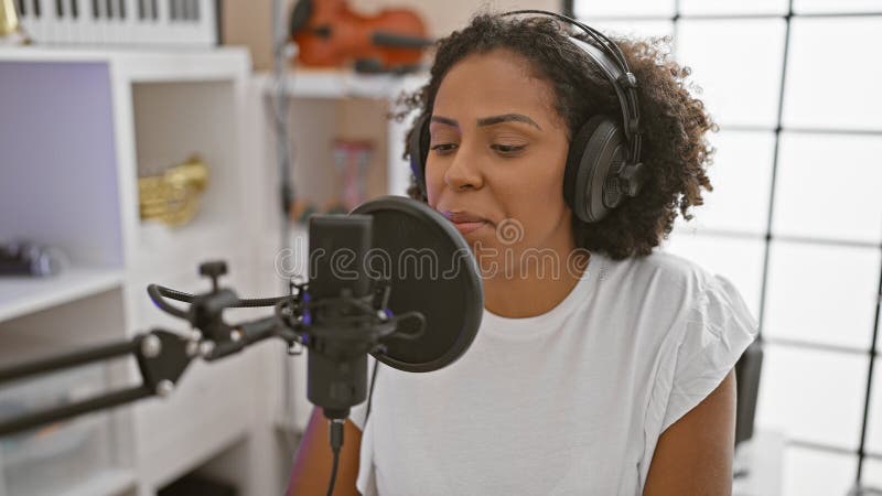 Afro-américaine chante dans un studio de musique photo stock