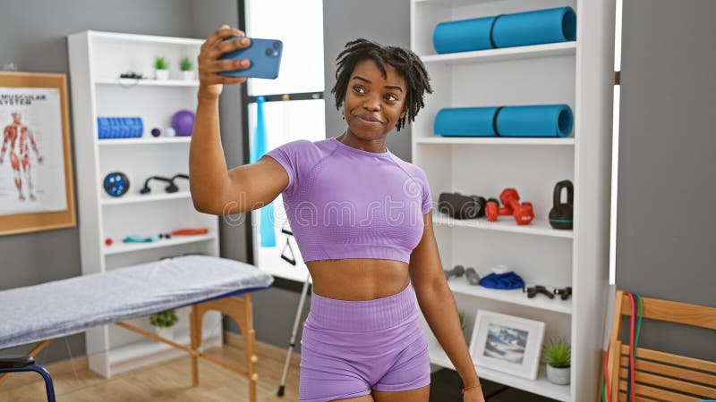 Afro-américaine en sportswear en selfie dans une clinique de réhabilitation gym photos libres de droits