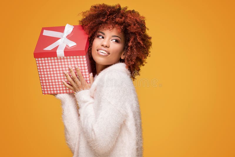 Afro dziewczyna pozuje z prezenta pudełkiem, ono uśmiecha się zdjęcia stock Afro dziewczyna pozuje z prezenta pudełkiem, ono uśmiecha się zdjęcia stock