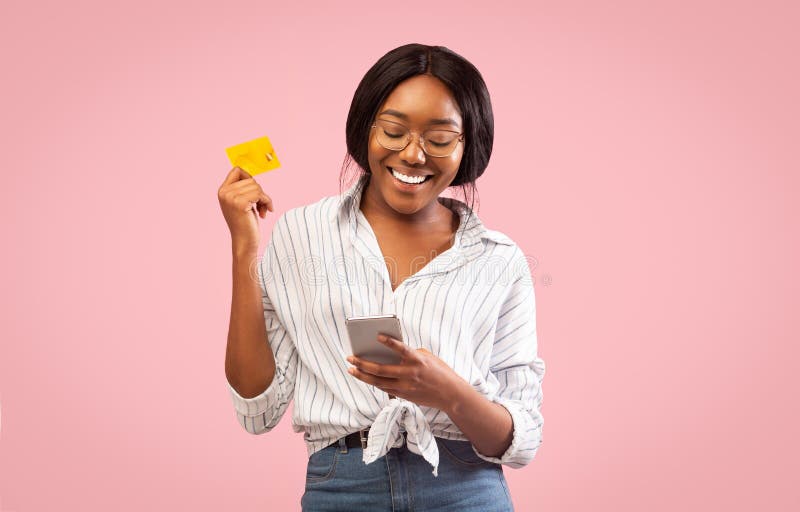 Afro Girl Using Cellphone And Credit Card Standing, Studio Shot