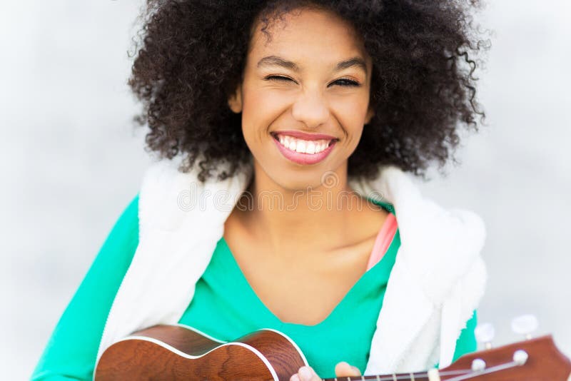 Afro kobieta bawić się ukulele zdjęcia royalty free Afro kobieta bawić się ukulele zdjęcia royalty free