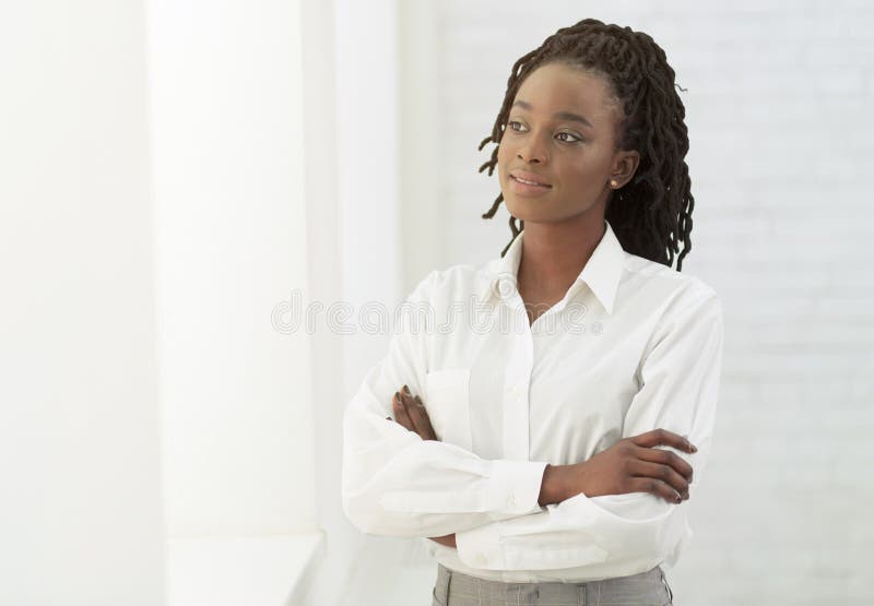 Afro Office Girl Crossing Hands Standing Next To White Wall