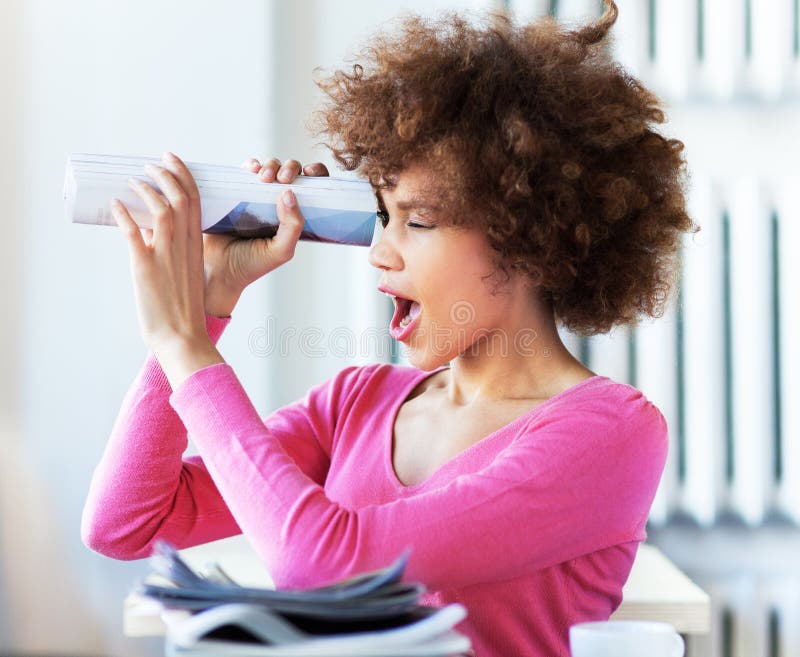 Afro woman using newspaper as spyglass royalty free stock photo