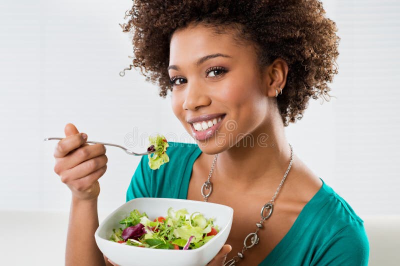 Afroamerikaner-Frau, die Salat isst