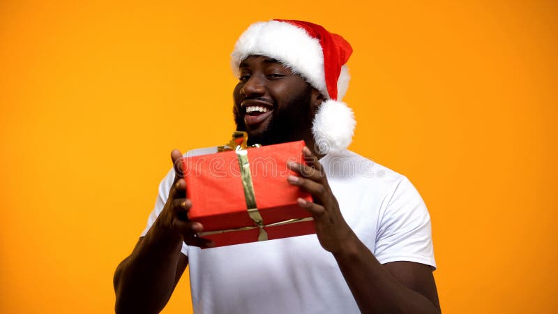 Afroamerikaner Sankt mit der Geschenkbox, die Kamera, Weihnachtsfestgeschenk betrachtet lizenzfreie stockfotos Afroamerikaner Sankt mit der Geschenkbox, die Kamera, Weihnachtsfestgeschenk betrachtet lizenzfreie stockfotos