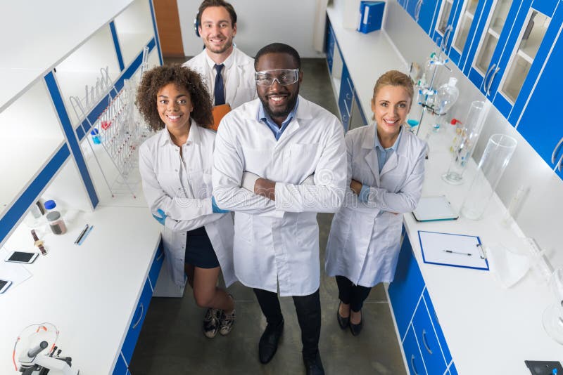 Afroamerikaner-Wissenschaftler-With Group Of-Forscher in modernes Labordem glücklichen Lächeln, Mischungs-Rennen Team Of Scientif