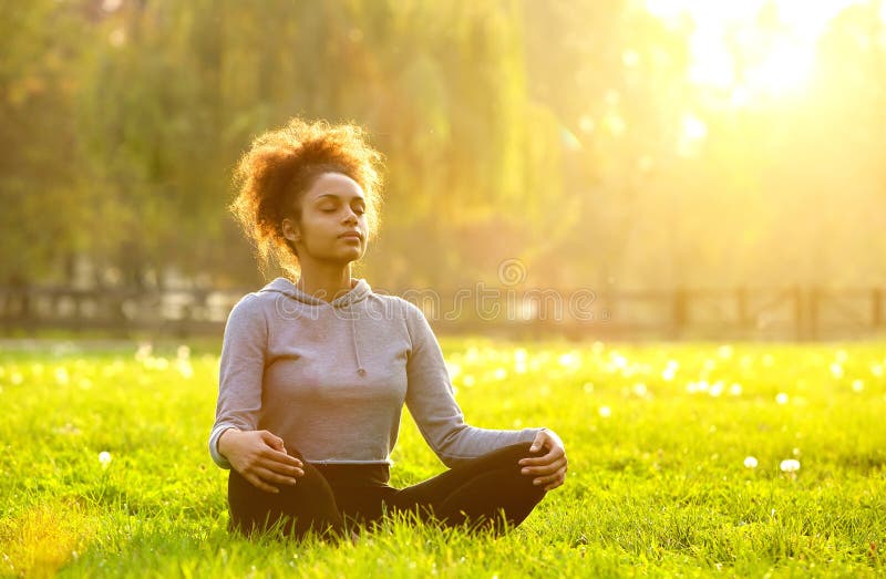Afroamerikanerfrau, die in der Natur meditiert