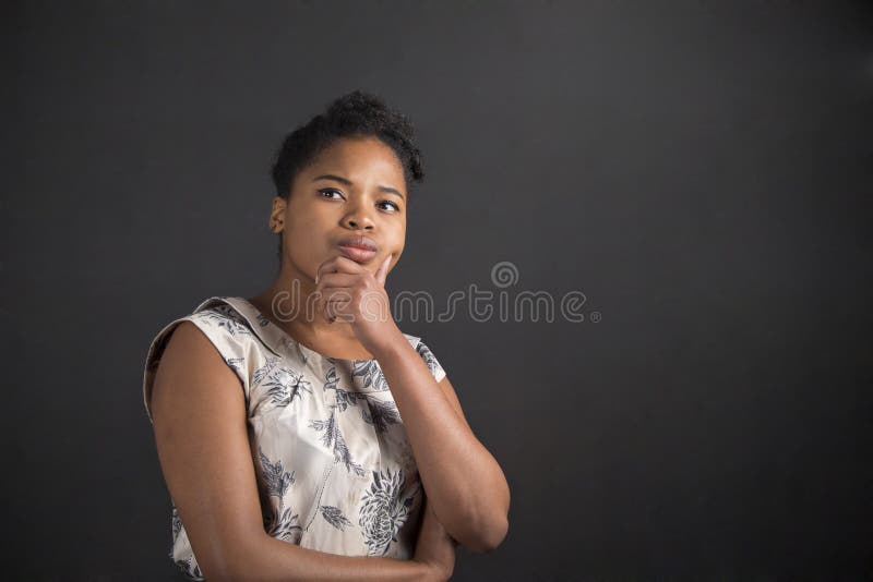Afroamerikanerfrau mit der Hand auf Kinn denkend auf Tafelhintergrund lizenzfreie stockbilder Afroamerikanerfrau mit der Hand auf Kinn denkend auf Tafelhintergrund lizenzfreie stockbilder