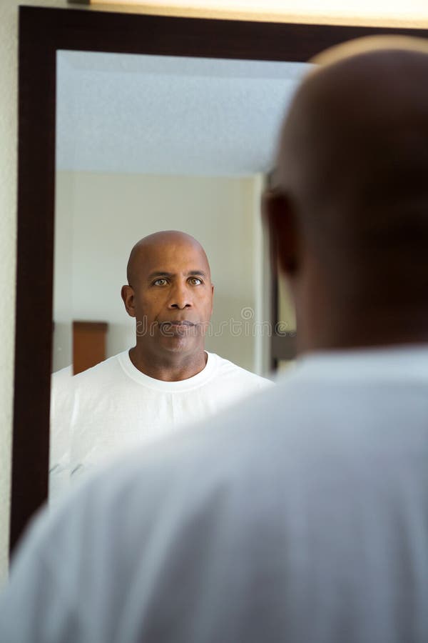 Afroamerikanermann, der im Spiegel schaut