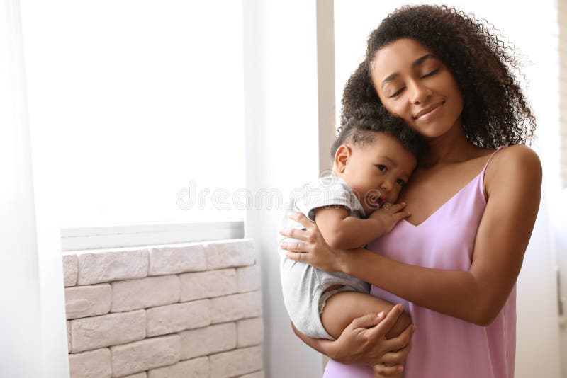 African-American women with her baby at home. Happiness of motherhood. African-American women with her baby at home. Happiness of motherhood