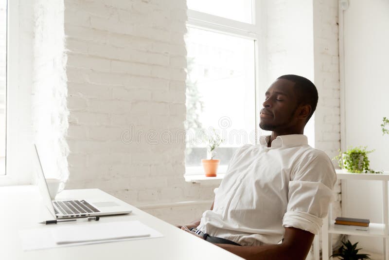 Afroamerykański mężczyzna relaksuje po tym jak pracy oddychania powietrze w domowym o