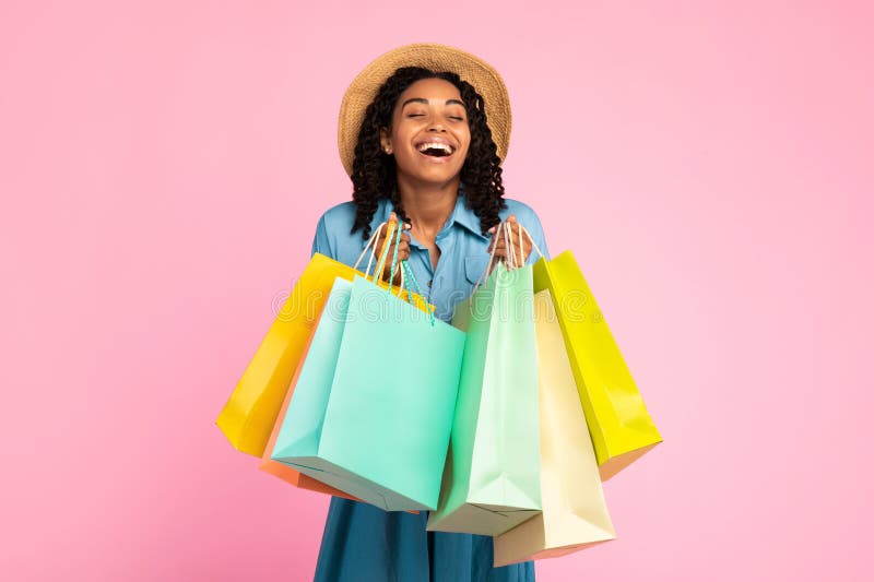 Afrykańska Kobieta Śmieje Się Holding Shopper Bags Na Różowym Studio Tło zdjęcie stock