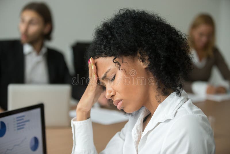 African american businesswoman feeling unwell suffering from headache migraine touching forehead at team meeting, upset black women employee frustrated by business problem or work stress, head shot. African american businesswoman feeling unwell suffering from headache migraine touching forehead at team meeting, upset black women employee frustrated by business problem or work stress, head shot