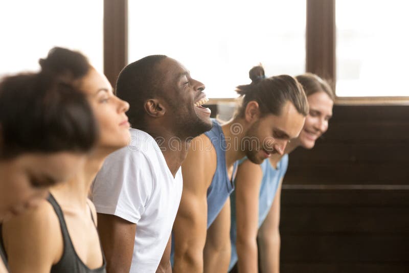 Afrykański mężczyzna śmia się robić joga lub desce przy grupowym szkoleniem zdjęcie royalty free Afrykański mężczyzna śmia się robić joga lub desce przy grupowym szkoleniem zdjęcie royalty free