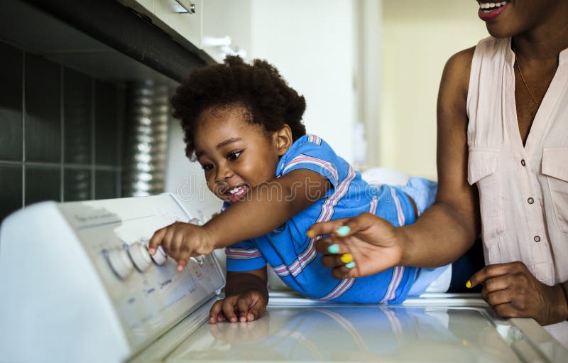 Afrykańskie pochodzenie dzieciaka pomaga mama robi pralni