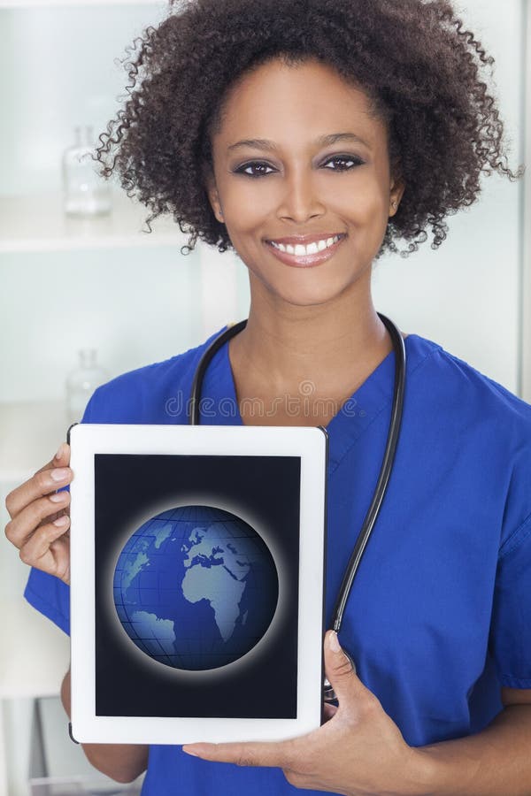 An African American female woman medical doctor with a tablet computer in hospital with a world map or globe on the screen. An African American female woman medical doctor with a tablet computer in hospital with a world map or globe on the screen