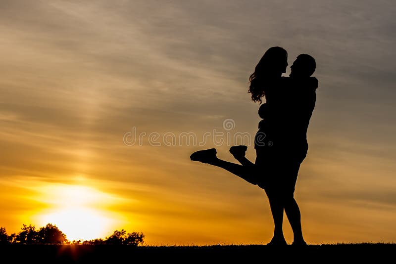 Vening meeting of lovers outdoors. Guy hugs the girl on a background of the evening sky. Romantic date in the mountains. Love playing in the park. Love story. Vening meeting of lovers outdoors. Guy hugs the girl on a background of the evening sky. Romantic date in the mountains. Love playing in the park. Love story.