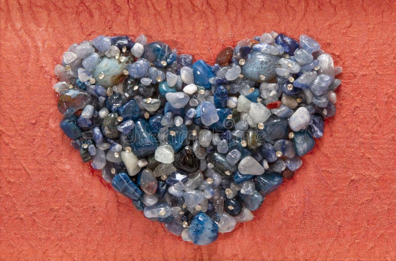 Agate blue crystals, heart shape closeup mineral, isolated on orange luxury painted background. Agate blue crystals, heart shape closeup mineral, isolated on orange luxury painted background.