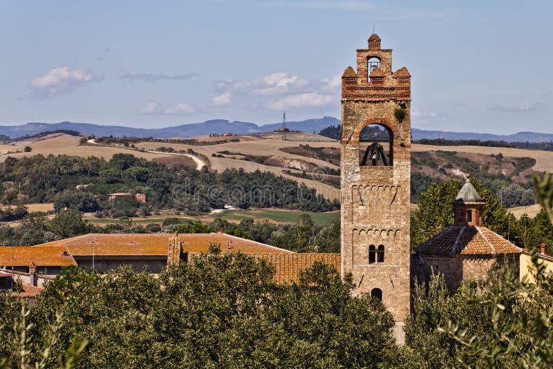 Romanesque basilica of Sant'Agata in Asciano and Crete Senesi landcapes on the background, Tuscany, Italy. Romanesque basilica of Sant'Agata in Asciano and Crete Senesi landcapes on the background, Tuscany, Italy