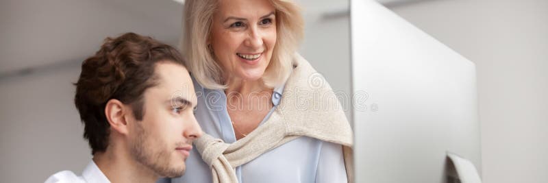 Aged mentor businesswoman helping to new employee with corporate program stock image Aged mentor businesswoman helping to new employee with corporate program stock image