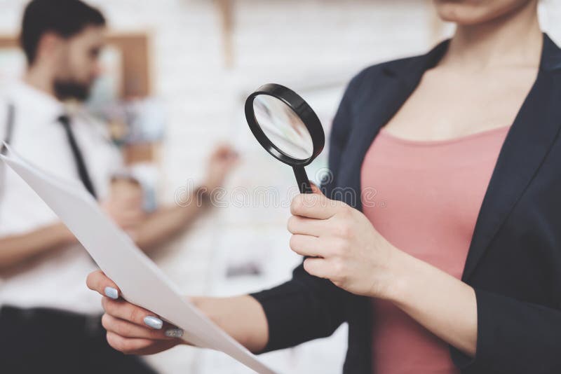 Agencia detective privada La mujer está presentando con el papel y la lupa, hombre está mirando el mapa de las pistas foto de archivo libre de regalías Agencia detective privada La mujer está presentando con el papel y la lupa, hombre está mirando el mapa de las pistas foto de archivo libre de regalías