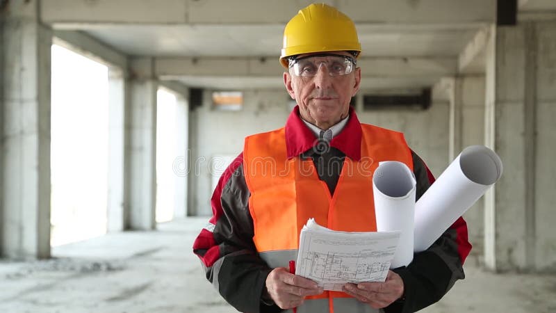 Agent de maîtrise général avec des dessins de bâtiment au site de projet