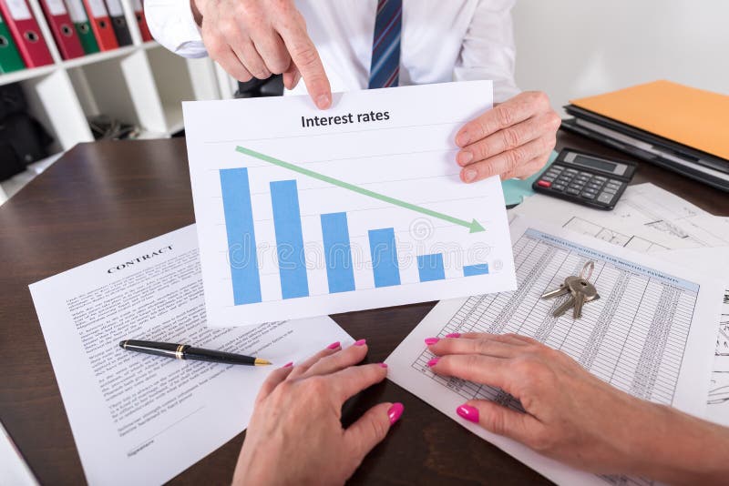 Agent immobilier montrant la diminution des taux d'intérêt photo stock Agent immobilier montrant la diminution des taux d'intérêt photo stock