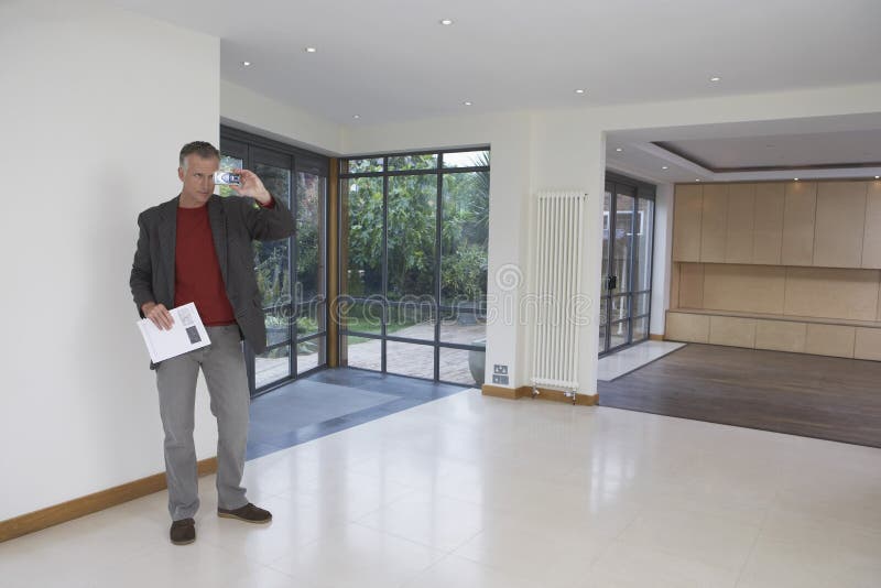 Full length of a male real estate agent photographing new property. Full length of a male real estate agent photographing new property