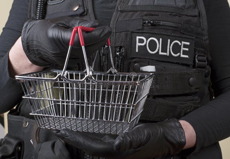Agente da polícia que guarda a cesta de fio pequena fotografia de stock Agente da polícia que guarda a cesta de fio pequena fotografia de stock