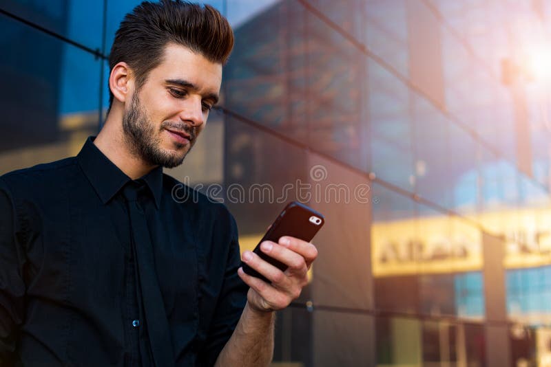 Agente de sexo masculino que usa al mensajero en el teléfono de célula imágenes de archivo libres de regalías Agente de sexo masculino que usa al mensajero en el teléfono de célula imágenes de archivo libres de regalías