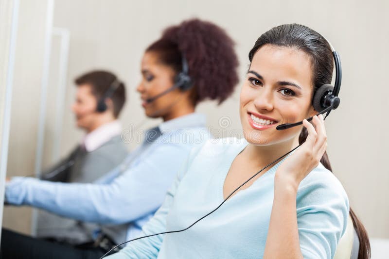 Agente femminile sorridente In Office di servizio di assistenza al cliente fotografia stock Agente femminile sorridente In Office di servizio di assistenza al cliente fotografia stock