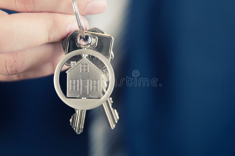 Agente inmobiliario que detiene llave del nuevo cierre del apartamento fotografía de archivo libre de regalías Agente inmobiliario que detiene llave del nuevo cierre del apartamento fotografía de archivo libre de regalías