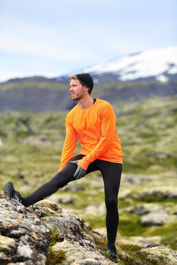 Runner man stretching legs after running in cross country trail run. Fit male runner exercise training outdoors in beautiful mountain nature landscape with Snaefellsjokull, Snaefellsnes, Iceland. Runner man stretching legs after running in cross country trail run. Fit male runner exercise training outdoors in beautiful mountain nature landscape with Snaefellsjokull, Snaefellsnes, Iceland.