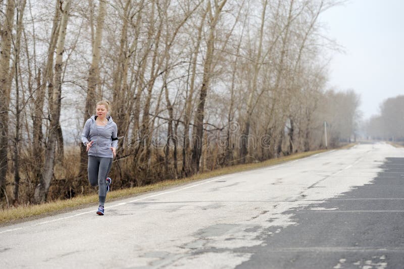 Agentvrouw die op weg in mooie aard lopen Joggingtraini stock afbeeldingen Agentvrouw die op weg in mooie aard lopen Joggingtraini stock afbeeldingen