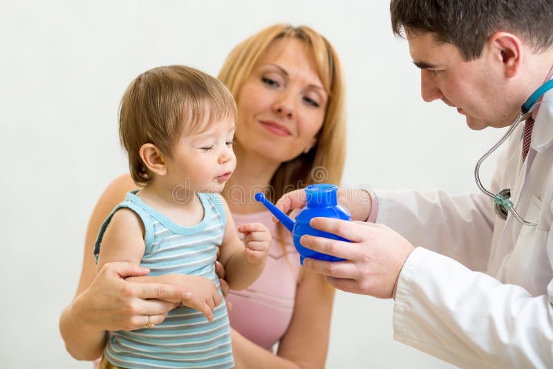 Doctor counseling mother and child about nasal irrigation or douche with neti pot. Doctor counseling mother and child about nasal irrigation or douche with neti pot