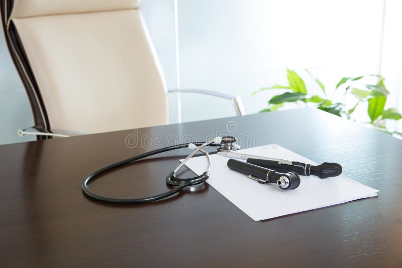 Aggiusti lo scrittorio della tavola dell'ufficio con lo stetoscopio e l'otoscopio immagine stock Aggiusti lo scrittorio della tavola dell'ufficio con lo stetoscopio e l'otoscopio immagine stock