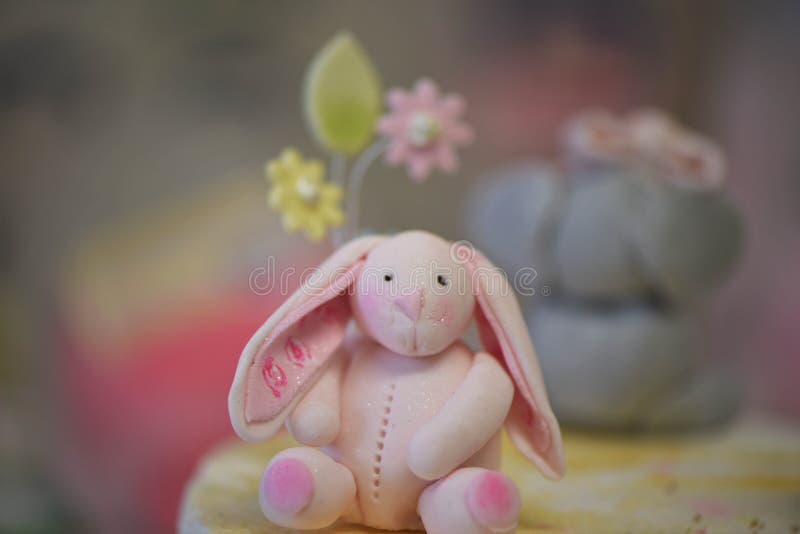 Agglutini il cappello a cilindro di una decorazione rosa ghiacciata del coniglio su una torta di compleanno dei childs immagini stock libere da diritti Agglutini il cappello a cilindro di una decorazione rosa ghiacciata del coniglio su una torta di compleanno dei childs immagini stock libere da diritti