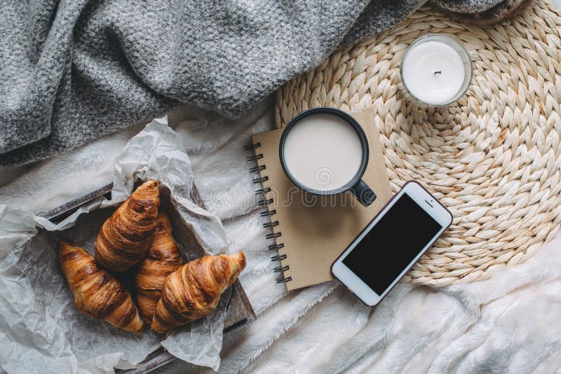 Mug with coffee and home decor on tray. Cozy sweater and sketchbook, winter weekend concept, top view. Mug with coffee and home decor on tray. Cozy sweater and sketchbook, winter weekend concept, top view