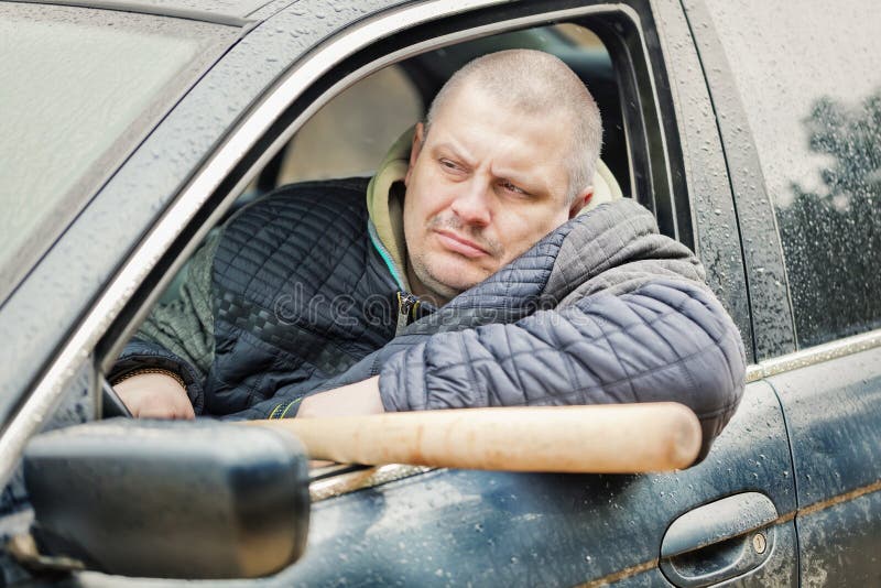 Aggressive Man with a Baseball Bat in Car at Outdoors Stock Image