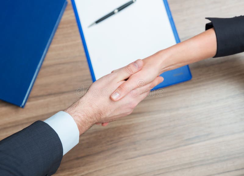 A agitação da mulher e do homem cede o papel e a pena na tabela imagem de stock A agitação da mulher e do homem cede o papel e a pena na tabela imagem de stock