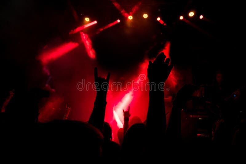 Aglomere-se em um concerto de rocha, chifres da rocha do metal pesado assinam dentro a névoa de um partido fotografia de stock Aglomere-se em um concerto de rocha, chifres da rocha do metal pesado assinam dentro a névoa de um partido fotografia de stock