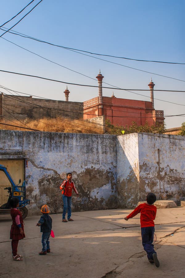 AGRA, LA INDIA - DICIEMBRE DE 2012: Cerca y niños de Taj Mahal que juegan a bádminton cerca de esta maravilla del mundo Uno la ma fotos de archivo AGRA, LA INDIA - DICIEMBRE DE 2012: Cerca y niños de Taj Mahal que juegan a bádminton cerca de esta maravilla del mundo Uno la ma fotos de archivo