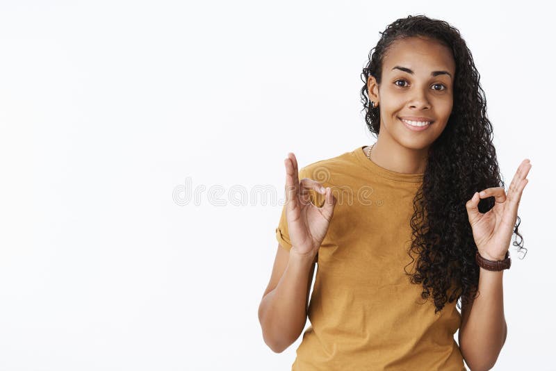 Agradable, estoy de acuerdo Retrato del amigo femenino afroamericano amistoso y satisfecho de la clase joven que anima y que es foto de archivo Agradable, estoy de acuerdo Retrato del amigo femenino afroamericano amistoso y satisfecho de la clase joven que anima y que es foto de archivo