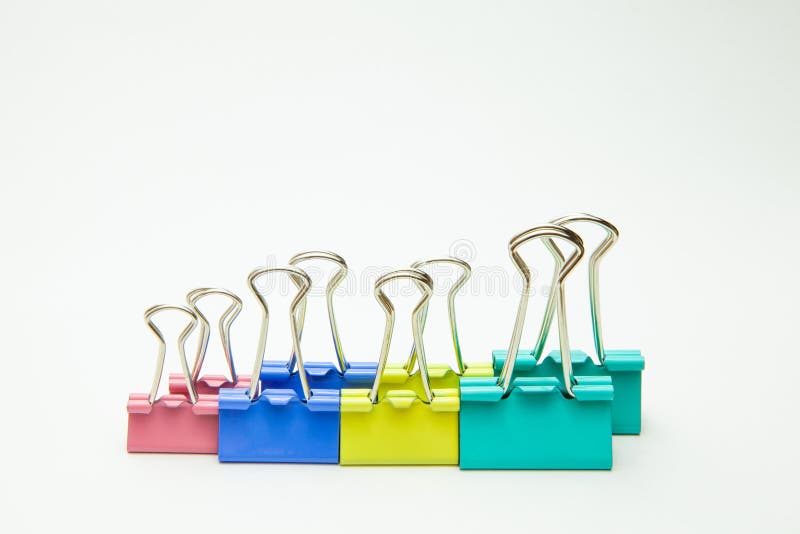 Agrafes pour le papier de différentes couleurs dans une rangée, plan rapproché sur un fond blanc photographie stock Agrafes pour le papier de différentes couleurs dans une rangée, plan rapproché sur un fond blanc photographie stock
