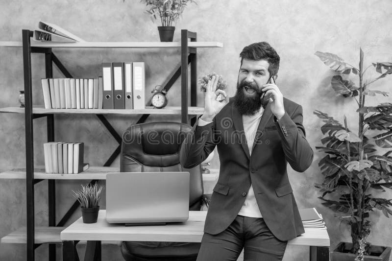 Agreed on this. Happy man talk on cell phone in office. Agreed. Showing OK gesture to agree royalty free stock photo