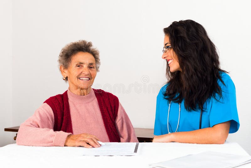 Nurse helping elder lady singing agreement to nursing home. Helping old woman to sign stock images, royalty-free photos and pictures