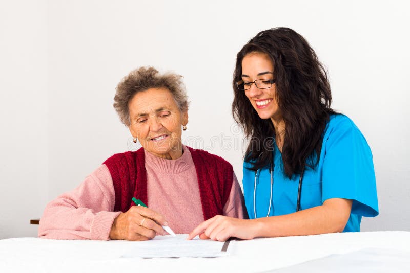 Nurse helping elder lady singing agreement to nursing home. Helping old woman to sign stock images, royalty-free photos and pictures