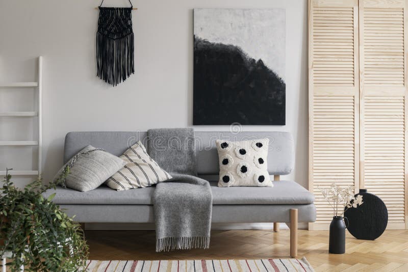 Agremán hecho a mano negro y pintura de lujo en la pared blanca de la sala de estar sofisticada interior con el sofá de moda gris imagen de archivo Agremán hecho a mano negro y pintura de lujo en la pared blanca de la sala de estar sofisticada interior con el sofá de moda gris imagen de archivo